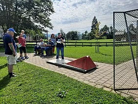 Mehrere Personen spielen Minigolf