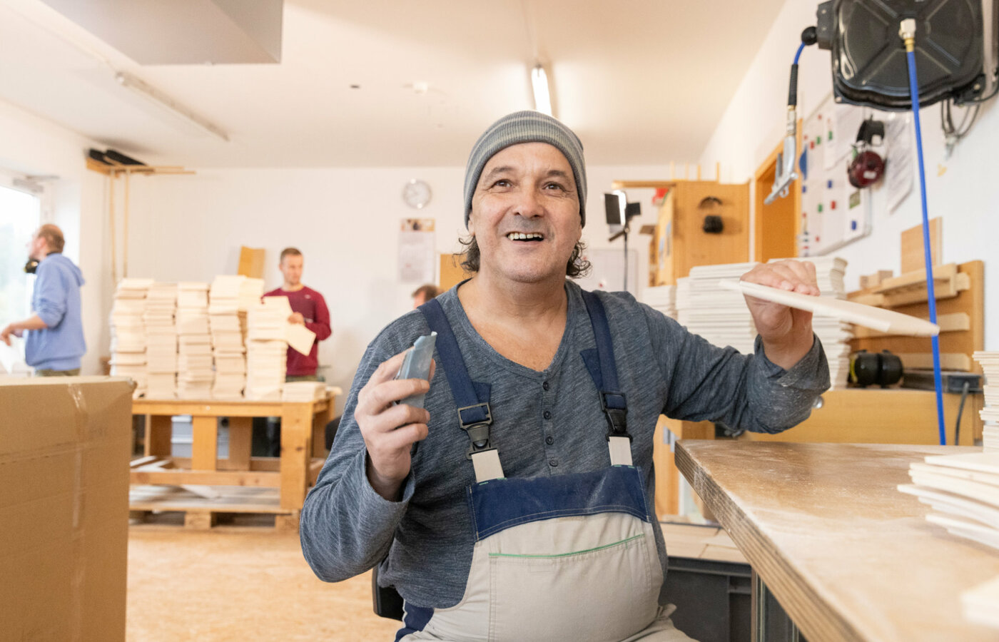 Ein Mitarbeiter einer Schreinerei bearbeitet Holz