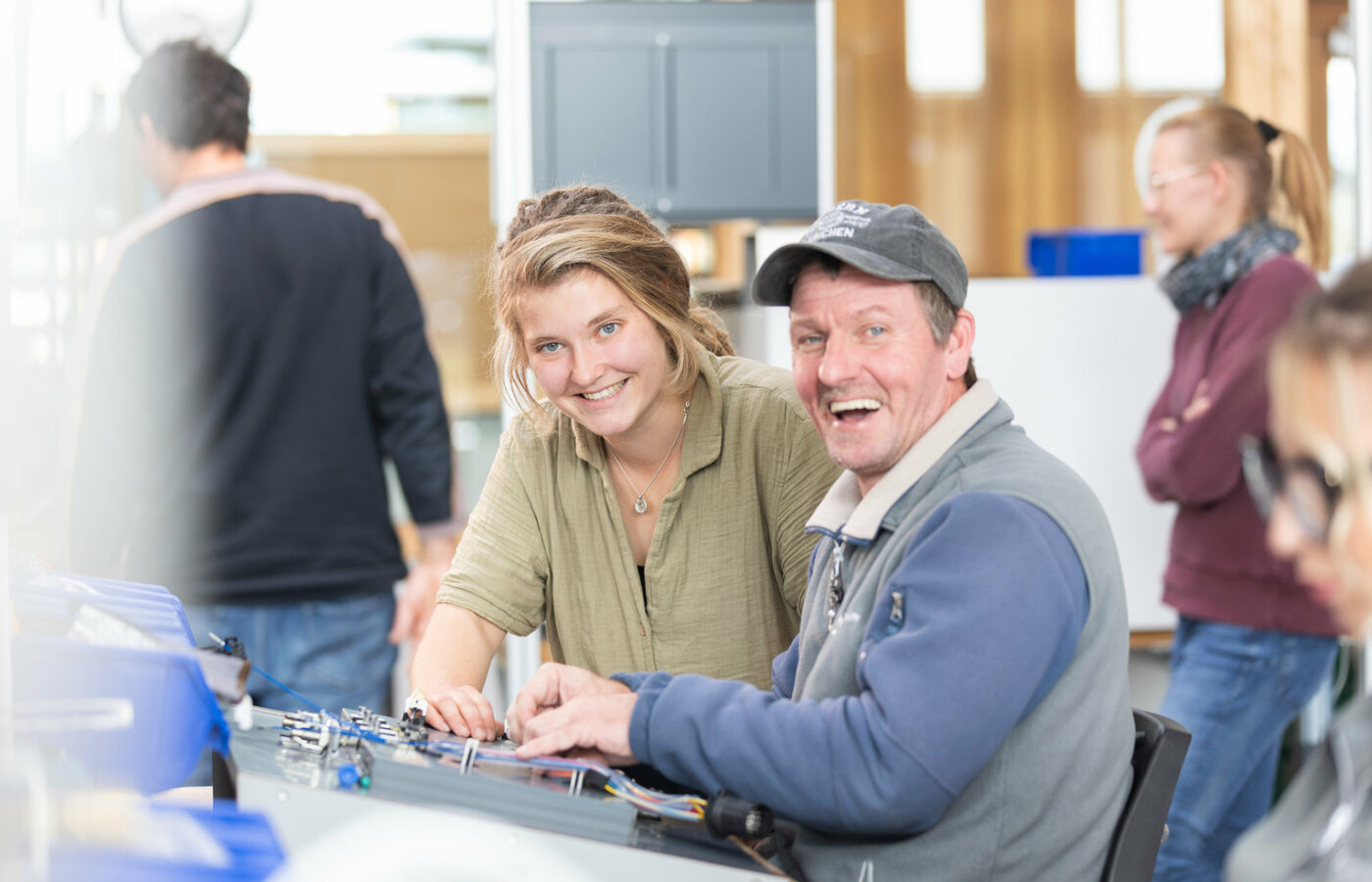 Ein Mann und eine junge Frau arbeiten gemeinsam in einer Werkstatt