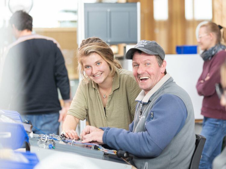 Ein Mann und eine junge Frau arbeiten gemeinsam in einer Werkstatt