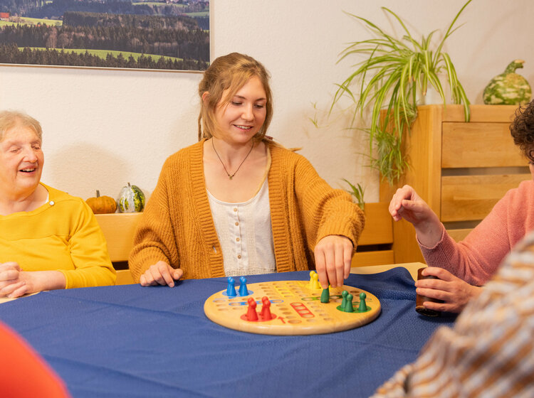 Mehrere Personen spielen gemeinsam an einem Tisch