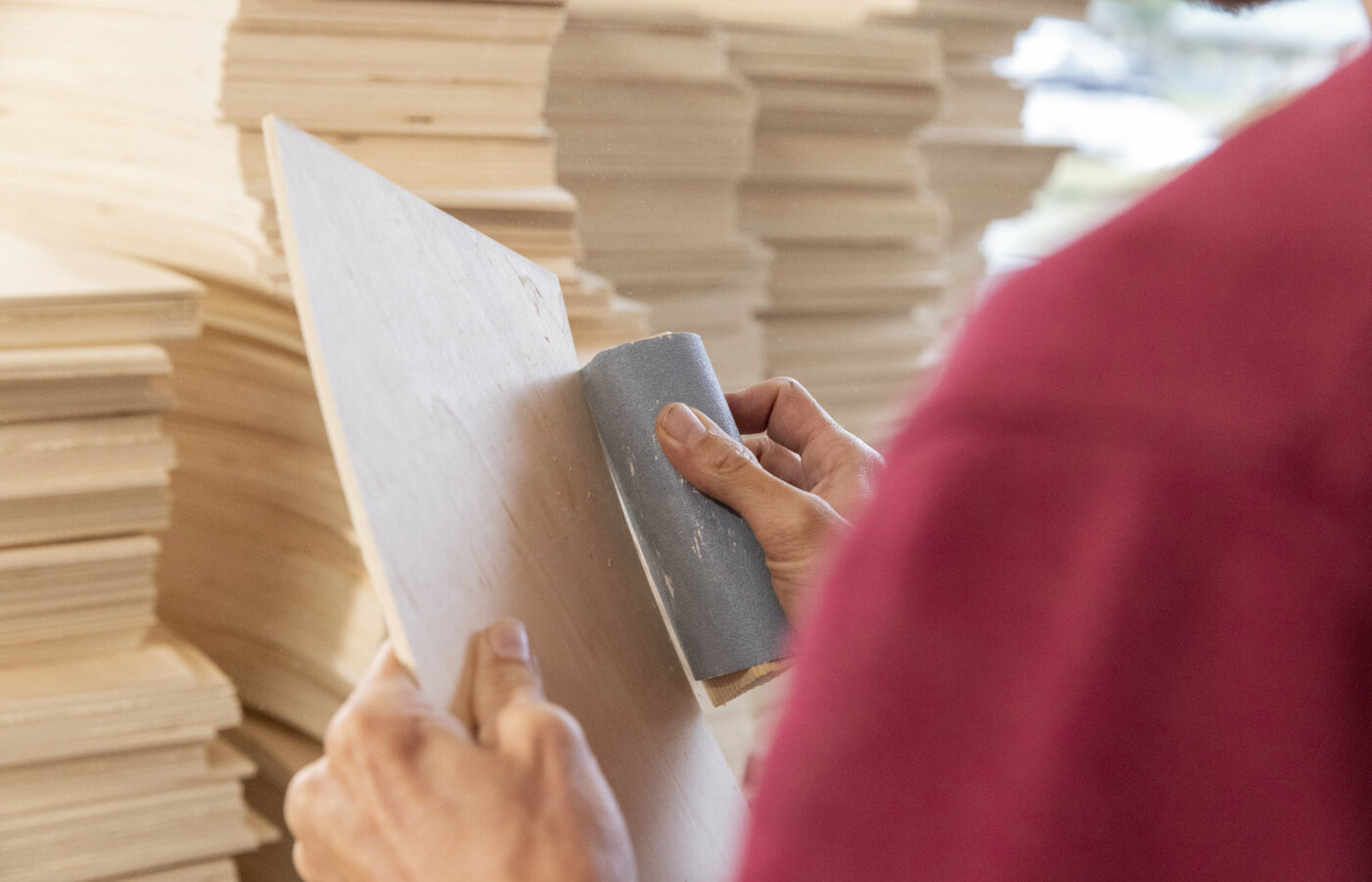 Holz wird mit Schleifpapier bearbeitet