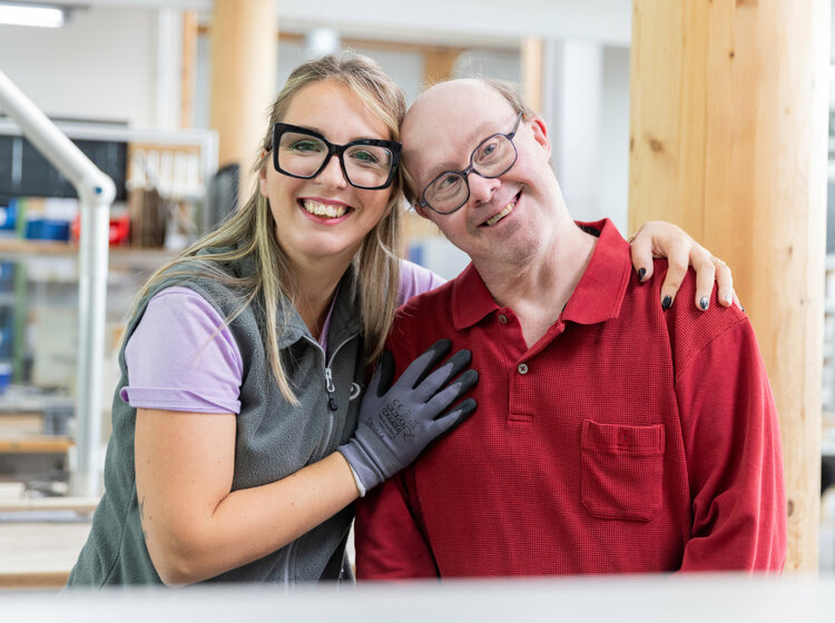 Ein Mann und eine Frau nebeneinander in einer Werkstatt