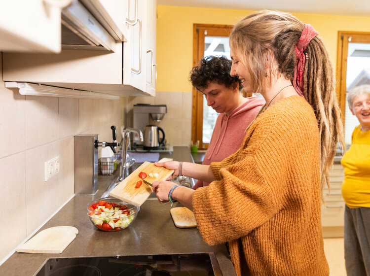 Mehrere Personen kochen gemeinsam in einer Küche