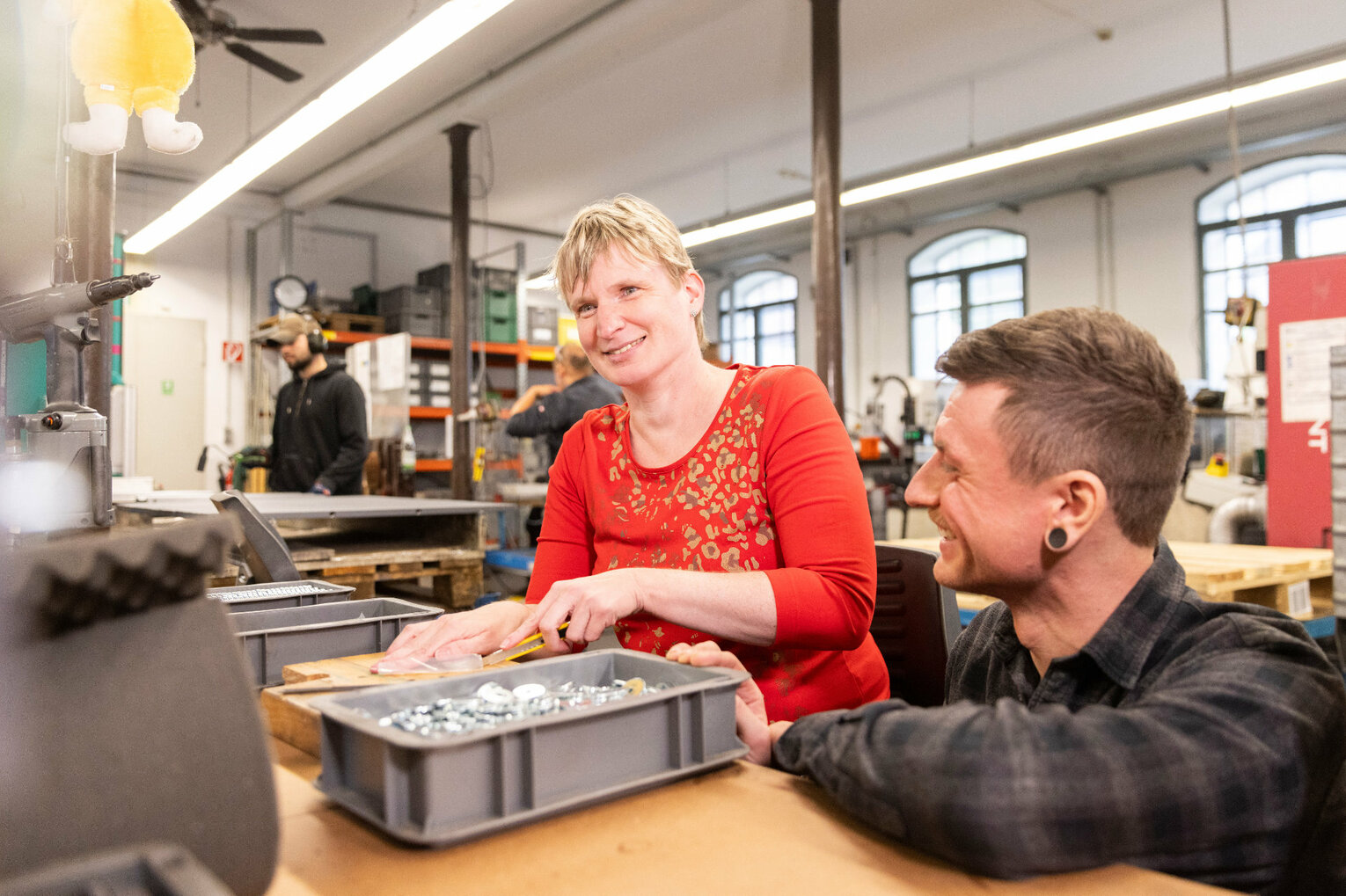 Eine Frau entgratet Metallteile mit einer Feile