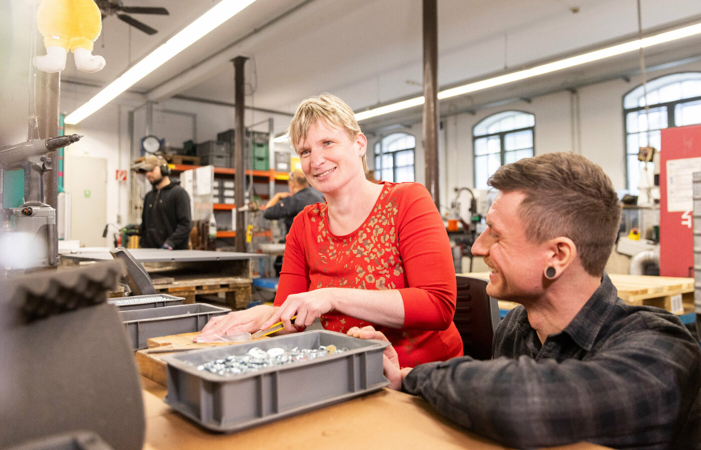 Eine Frau entgratet Metallteile mit einer Feile