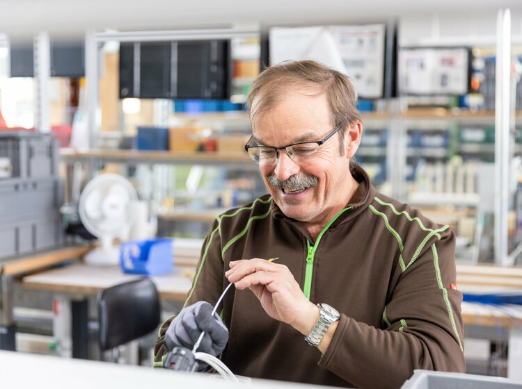 Ein Mann mit Brille isoliert ein Kabel ab