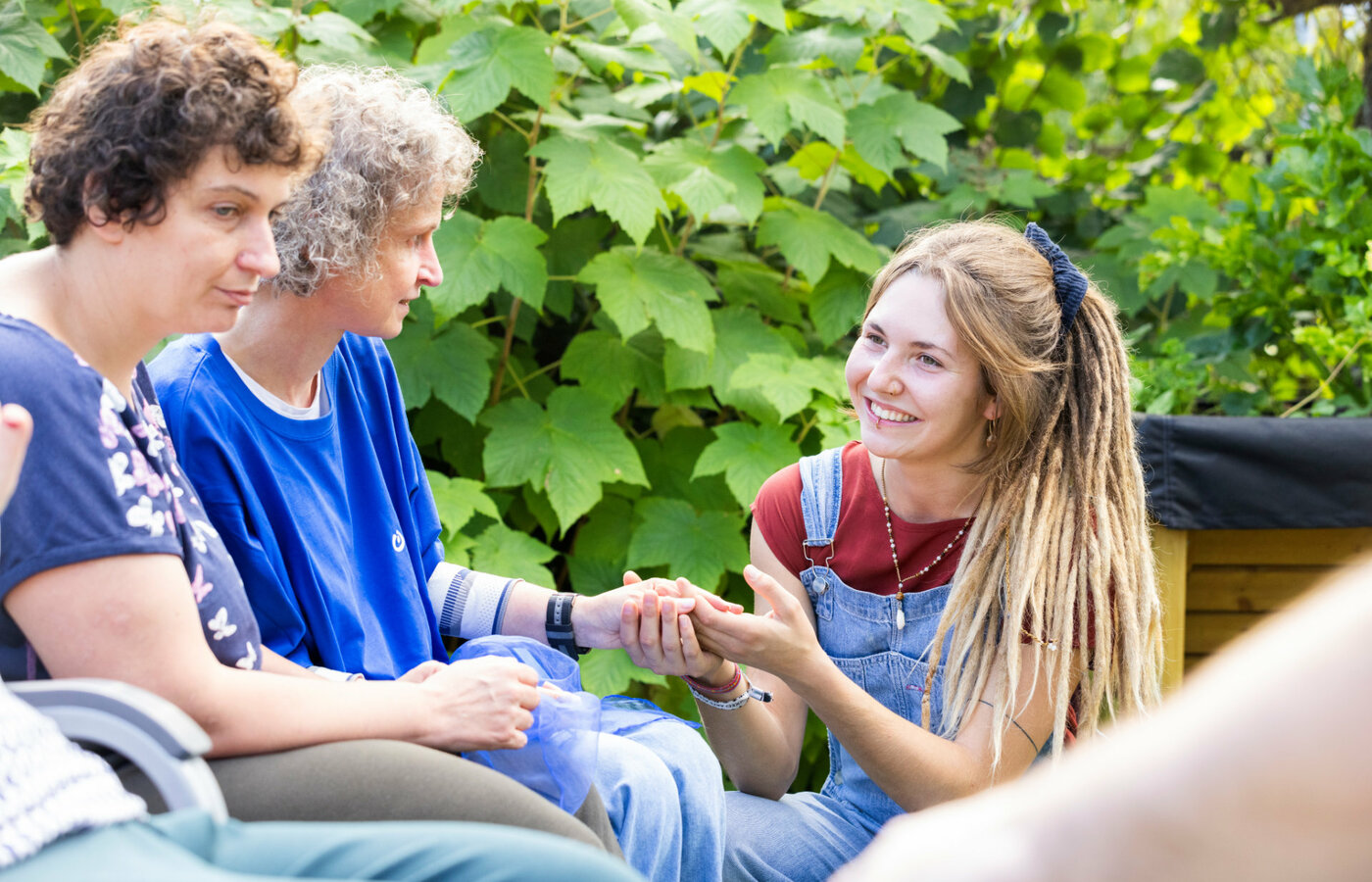 Mehrere Personen sitzen zusammen in einem Garten