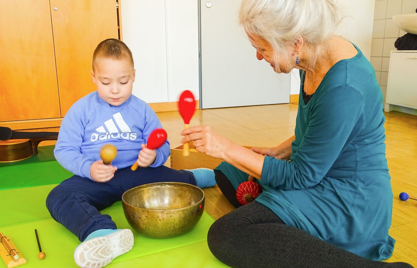 Ein Kind macht Musik mit Rasseln