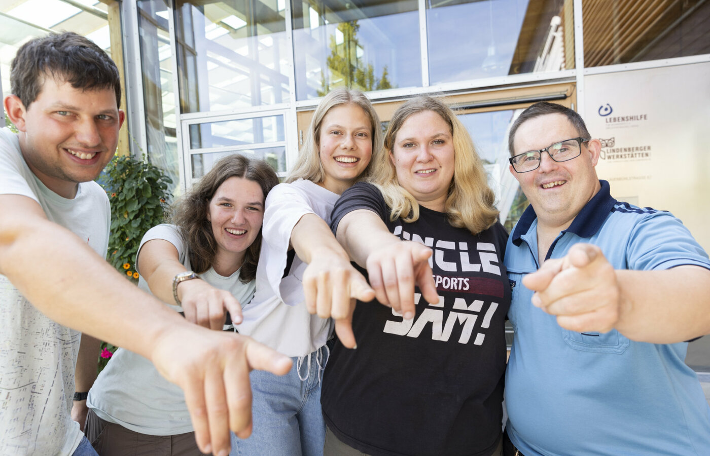 Mehrere Personen zeigen mit dem Zeigefinger in die Kamera