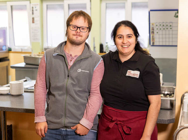 Ein Mann und eine Frau stehen in einer Cafeteria nebeneinander