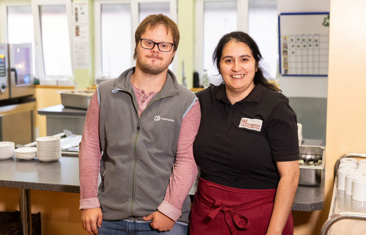 Ein Mann und eine Frau stehen in einer Cafeteria nebeneinander