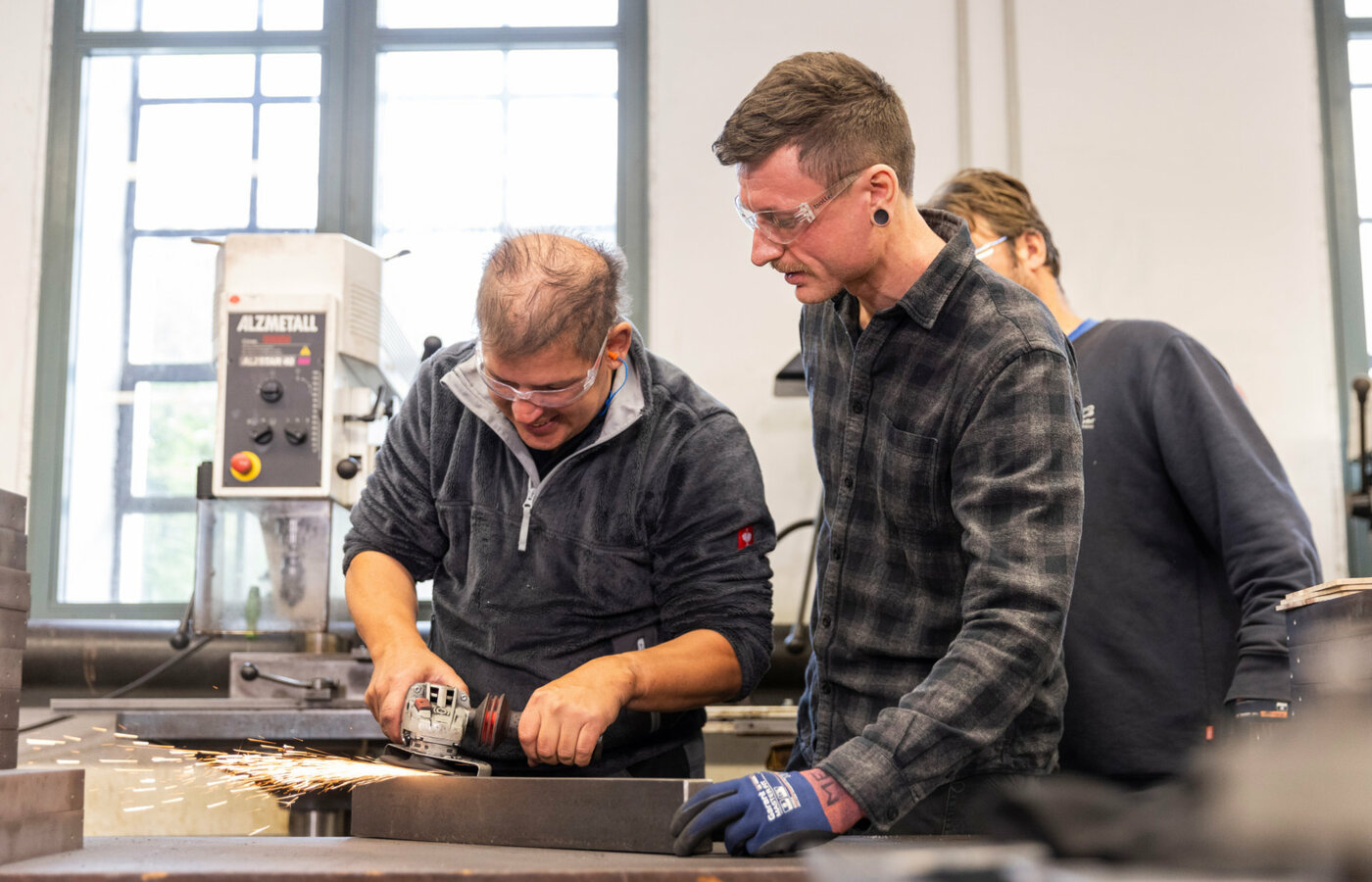 Ein Mann bearbeitet Metall mit einer Schleifmaschine