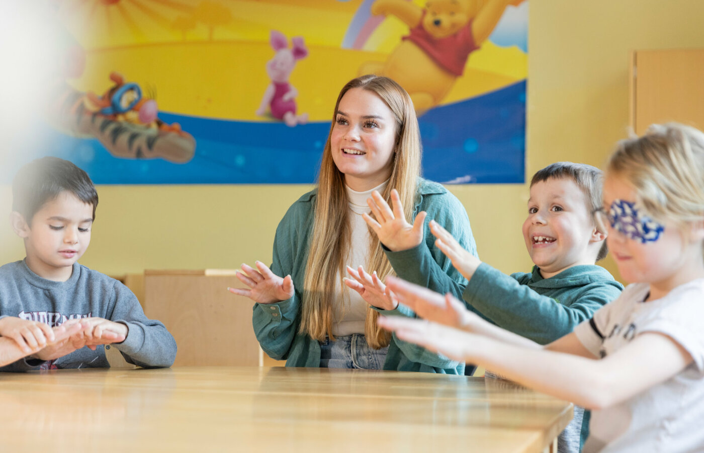 Eine Frau und Kinder singen an einem Tisch zusammen